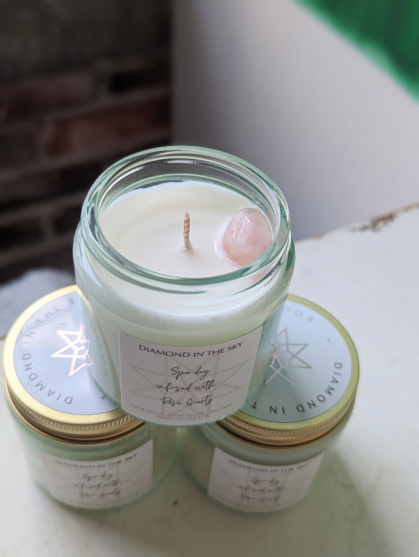 close up of spa soy candle- hand poured candle with pink gemstone