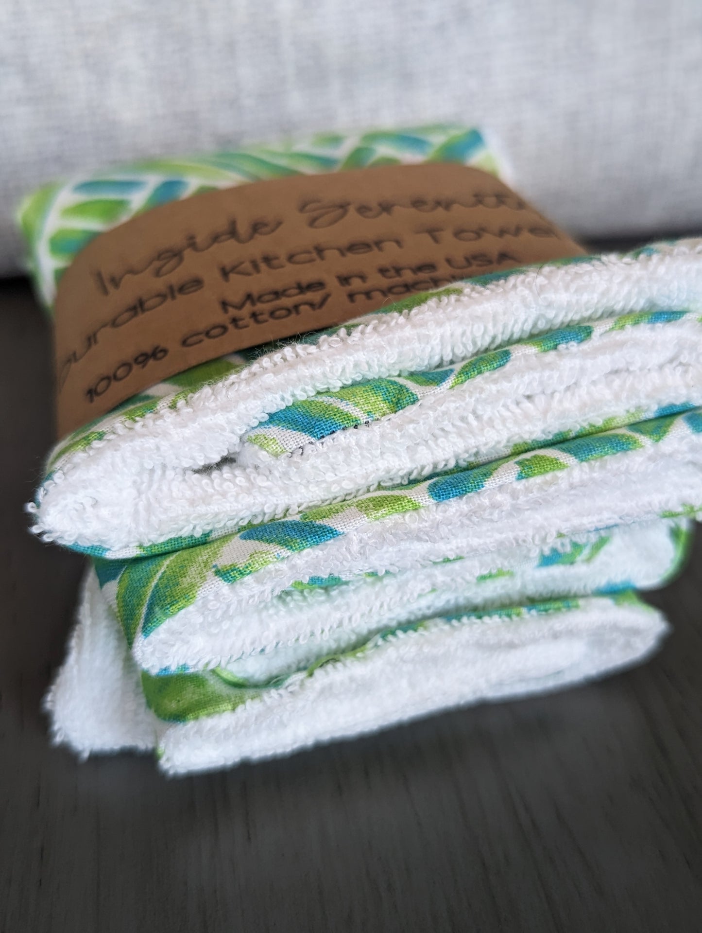 Patterned green kitchen towel mini with white terry cloth on the bottom for durability.