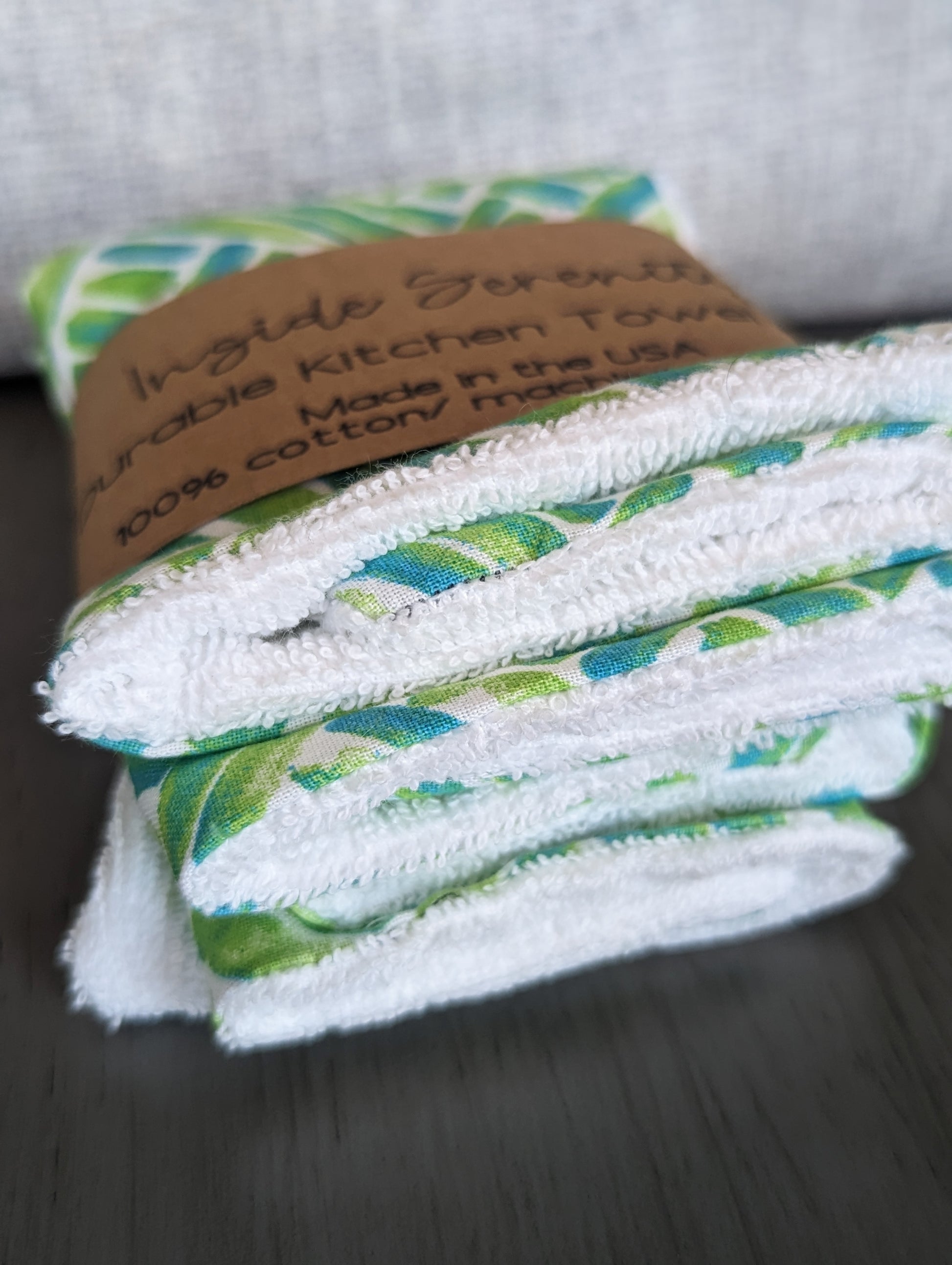 Patterned green kitchen towel mini with white terry cloth on the bottom for durability.