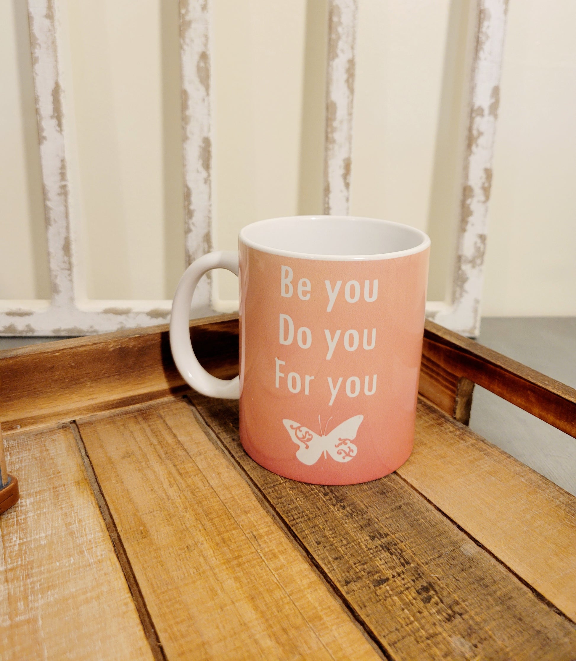 Pink 11 oz ceramic coffee mug on a tray that says be you do you for you 