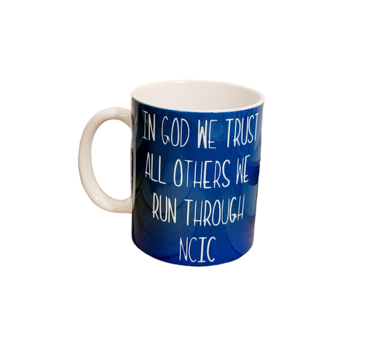 11 oz. coffee mug. Blue base that says "In God we trust. All others we run through NCIC"